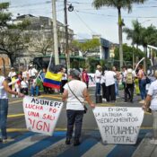 Personas en una calle protestando a la afuera de la NUEVA EPS